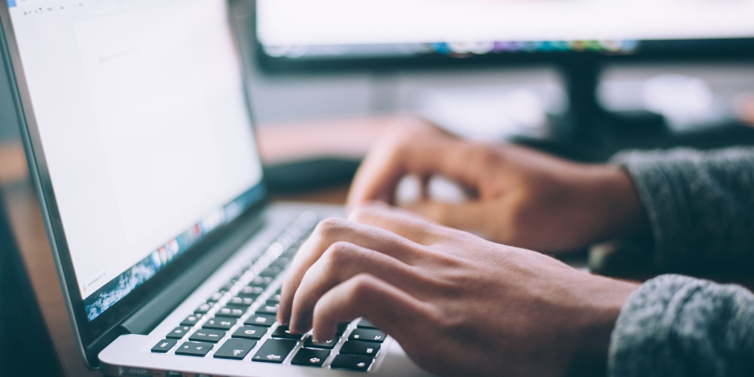 mannelijke handen die op het toetsenbord van een laptop typen